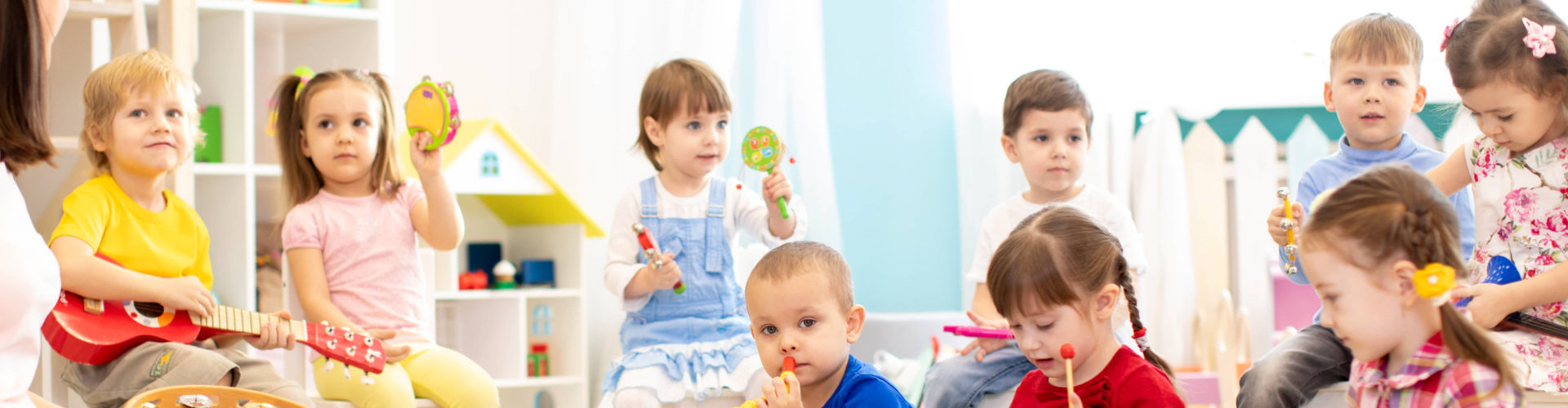 group of kindergarten children play with musical toys